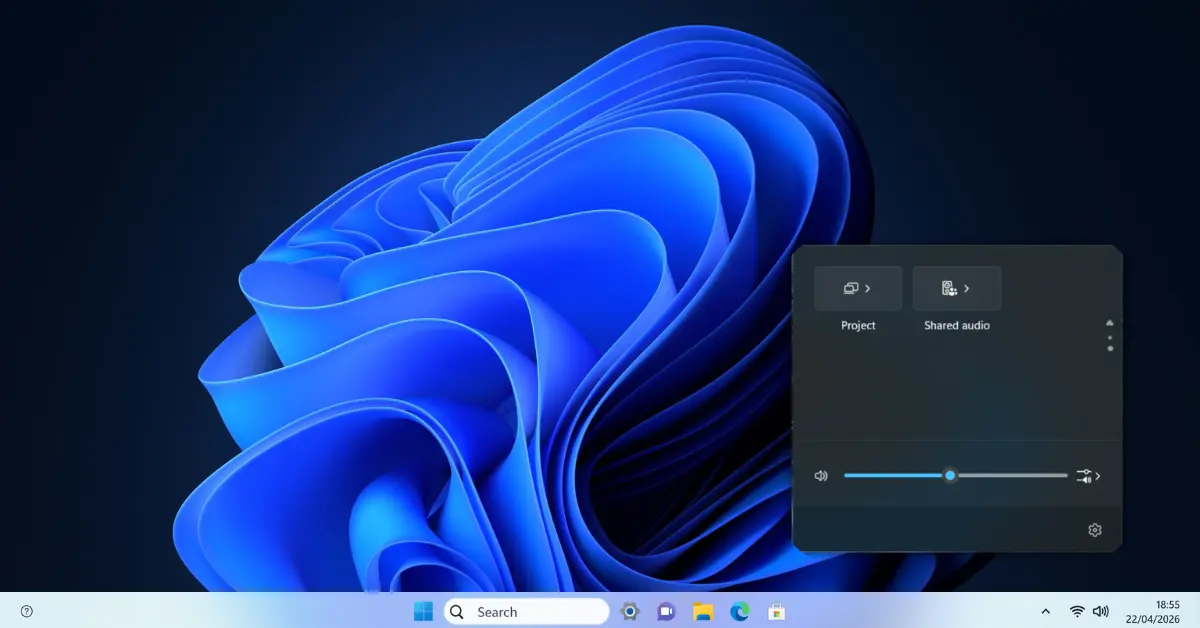 Windows 11 taskbar showing the audio flyout expanded after clicking the speaker icon, with the volume slider visible and an arrow button to the right that opens a device selection list showing available audio outputs including speakers and headphones